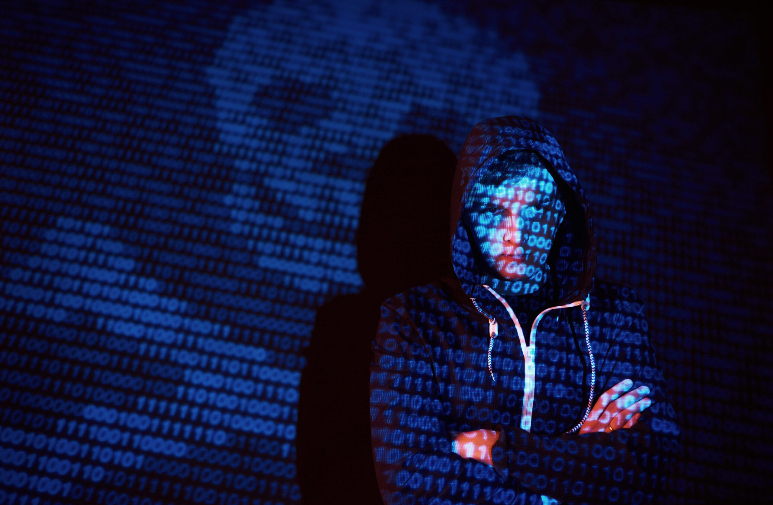 Cyber attack with unrecognizable hooded hacker using virtual reality, digital glitch effect.